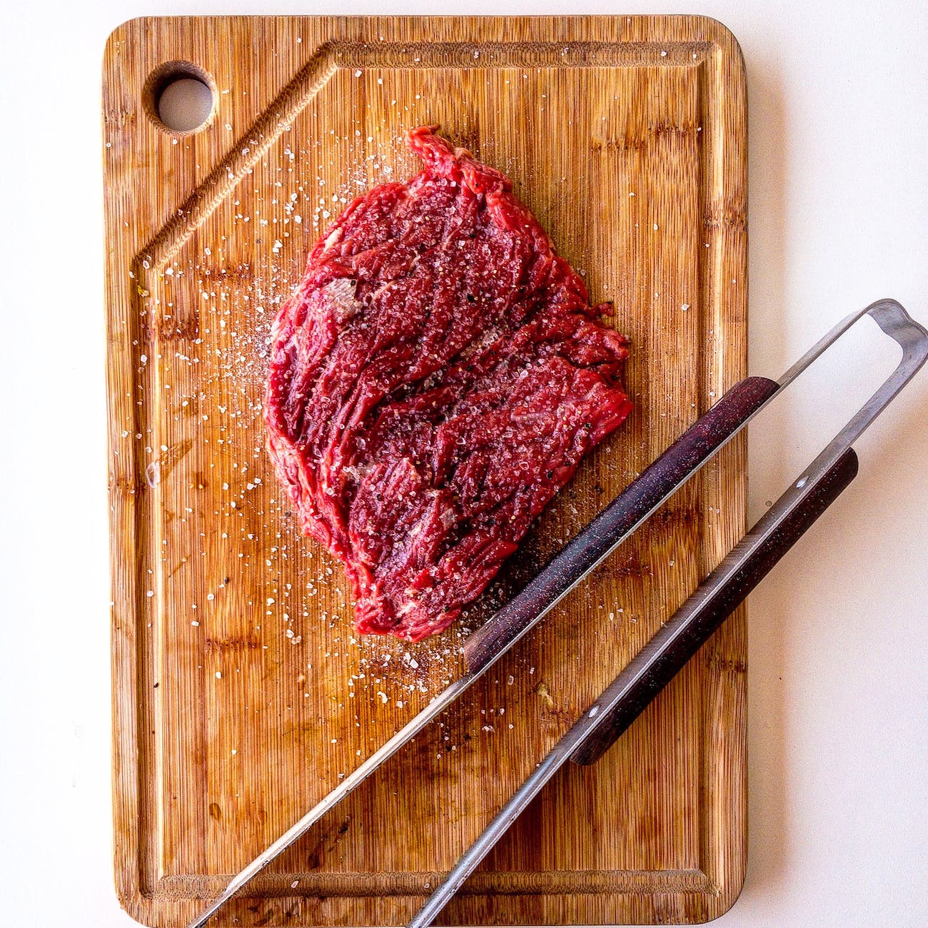 brown wooden chopping board with meat on top